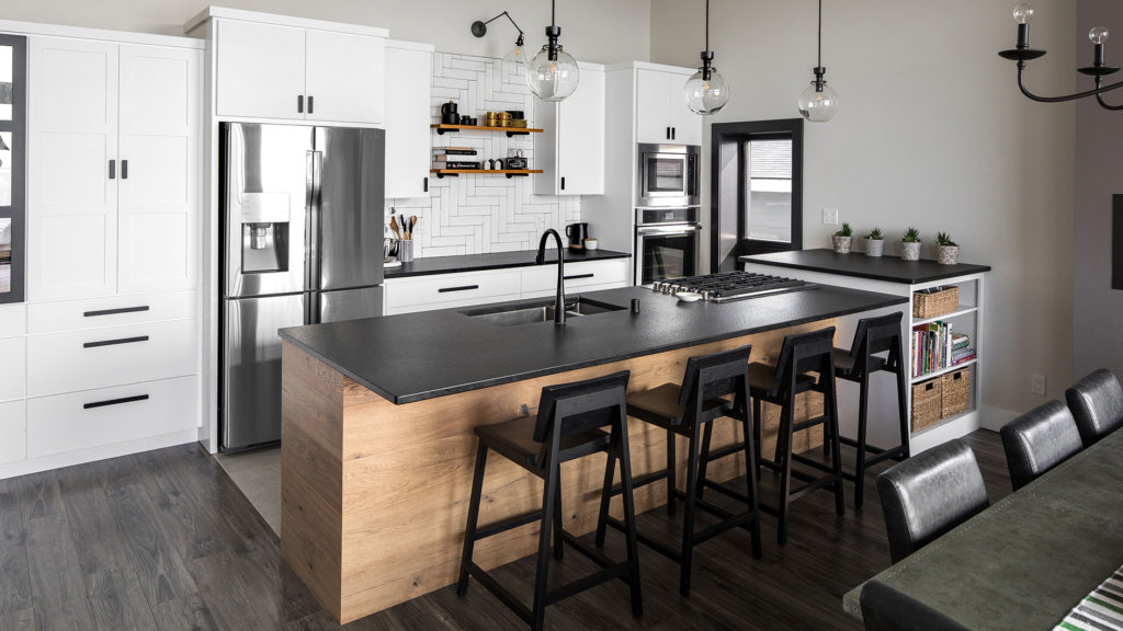 Custom white slab and shaker cabinets in modern kitchen with black granite and wood accents.
