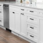 White shaker kitchen cabinets with black square hardware and white quartz countertops.